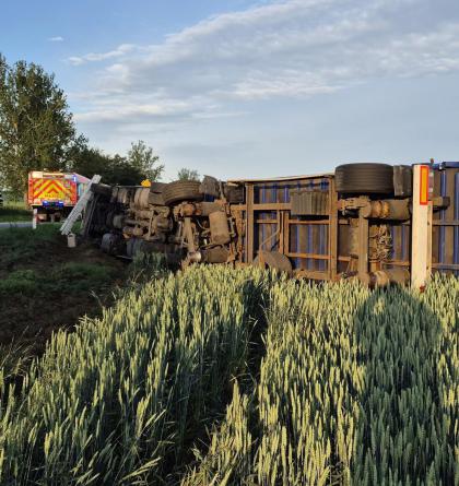 Kamion skončil po nehodě převrácený v poli